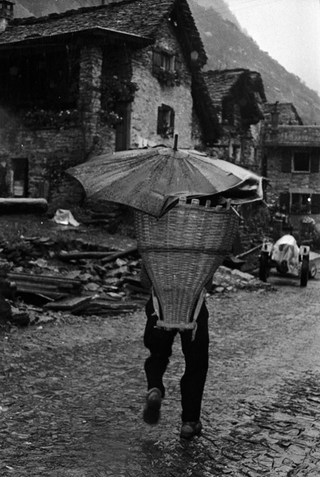 Uomo che trasporta una gerla di pane appena sfornato a Sonogno