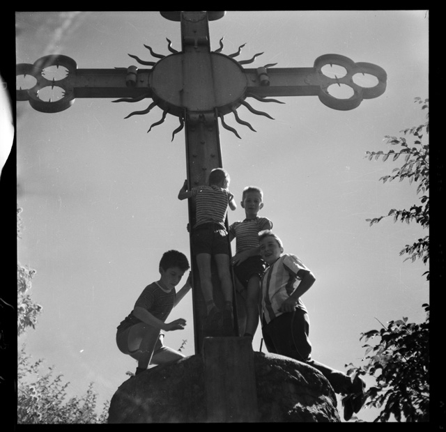 Ragazzi mentre si arrampicano sulla croce dell'oratorio di San Bernardo