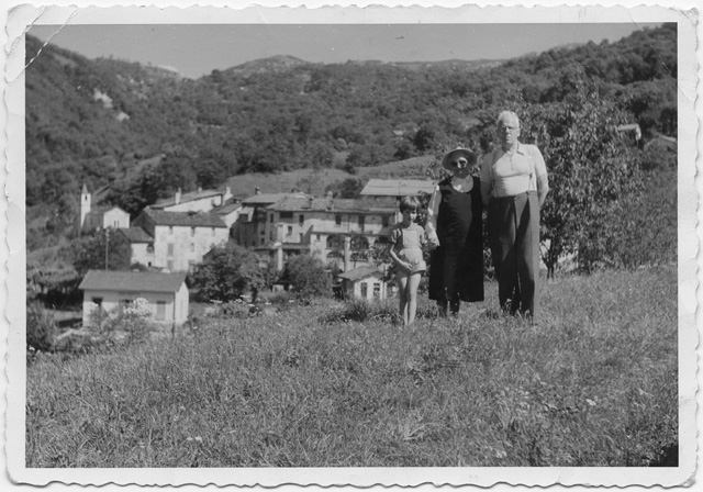 Coppia con bambina in posa in un prato con Odogno sullo sfondo