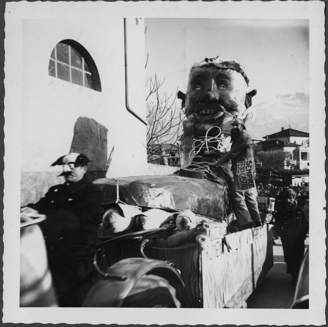 Ritratto d'uomo su un carro di carnevale a forma di scarpa