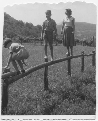 Donna con bambini in equilibrio su di una staccionata sulla piana di Odogno