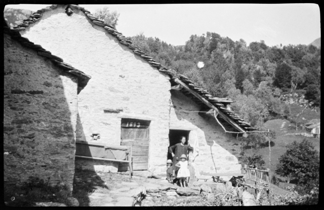 Donna con bambini davanti ad una cascina a Gola di Lago