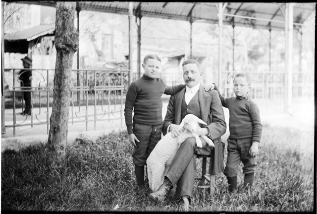 Uomo con due bambini in posa con un agnello