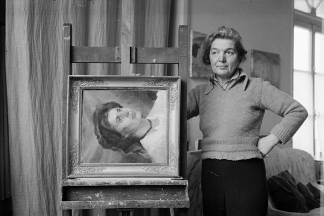 La pittrice Regina Conti in posa un suo dipinto