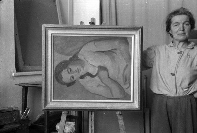 La pittrice Regina Conti in posa con un suo dipinto