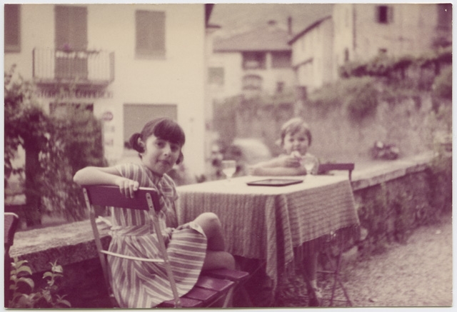 Bambine sedute ai tavolini esterni della pensione Eden