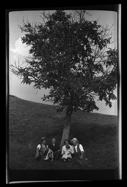 Famiglia Antonini seduta sotto a un albero con una coppia di amici a Condra
