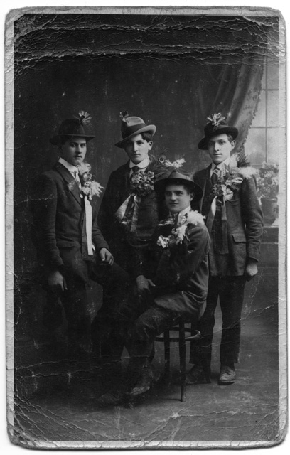 Quattro giovani in posa vestiti da festa